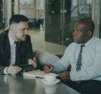 Two businessmen discussing work over coffee.